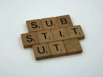 Scrabble stones forming the word “Substitut” short of an ‘e’