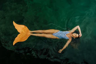A woman with a big mono-fin swimming in a pool