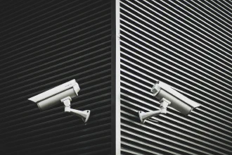 Two security cameras mounted on the walls of a building